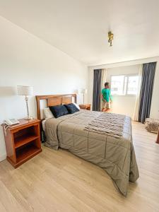 Eine Frau steht in einem Schlafzimmer mit einem Bett in der Unterkunft Gran Hotel Buenos Aires in Buenos Aires