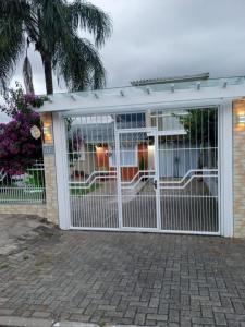 een afgeschermde veranda met een witte poort bij Suíte da Cris em Gramado in Gramado