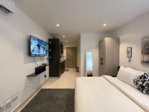 a hotel room with a bed and a tv on the wall at The Lennox Luxury Suites & Apartments in Accra