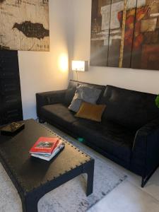 a living room with a black couch and a table at Logement Le Bois Le Prêtre Pont-à-Mousson in Pont-à-Mousson