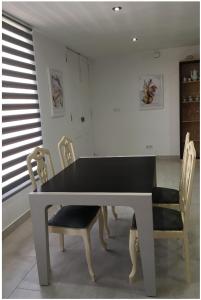 mesa de comedor con 2 sillas y mesa negra en Apartamento en Aguiño, en Ribeira