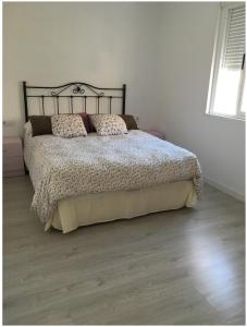 1 dormitorio con 1 cama grande y 2 almohadas en Apartamento en Aguiño, en Ribeira