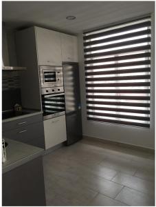 una cocina con fogones y una ventana con persianas en Apartamento en Aguiño, en Ribeira