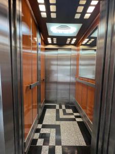a hallway of a elevator with a checkered floor at Apartament Sportowa in Suwałki