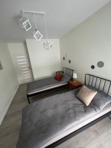 1 Schlafzimmer mit 2 Betten, einem Tisch und Lampen in der Unterkunft Apartament Sportowa in Suwałki