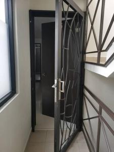 Una puerta negra en una habitación con ventana en lindo y cómodo departamento familiar, en Ciudad de México