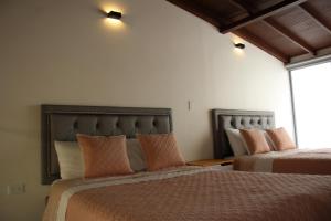 two beds sitting next to each other in a bedroom at Hotel Plaza El Santuario in Santuario