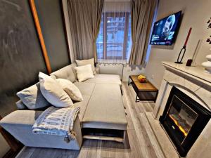 ein Wohnzimmer mit einem Sofa und einem Kamin in der Unterkunft 1 bedroom luxury apartment Milena -free parking in Pamporowo