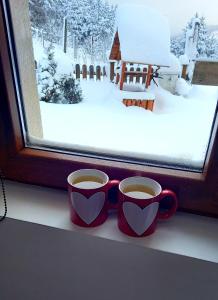 two cups of coffee sitting on a window sill at Zlatna Jabuka apartman in Prijepolje