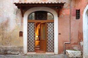 an entrance to a building with a wooden door at Rustico La Rosa in Tivoli