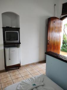 Zimmer mit einem Bett und einem TV auf der Theke in der Unterkunft Hotel Xaréu in Ubatuba