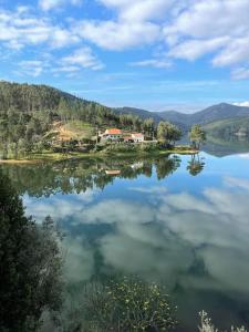 a large lake with a house in the middle of it at Casa dos pássaros in Carril