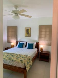 a bedroom with a bed with blue pillows and a ceiling fan at Stunning Loft 2 Floor Unit with Balcony in Contadora