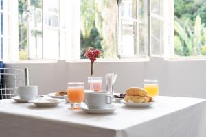 uma mesa branca com alimentos e bebidas ao pequeno almoço em Pousada Villa Real em Sabará