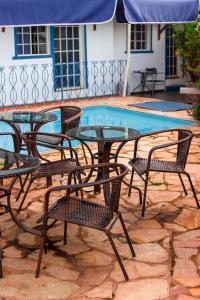 uma mesa de vidro e cadeiras ao lado de uma piscina em Pousada Villa Real em Sabará