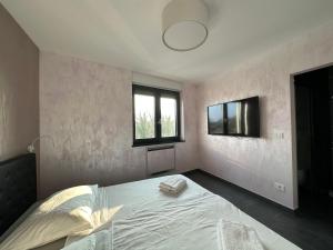a bedroom with a bed and a tv on the wall at Seaview in Funtana