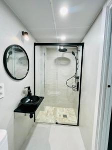 een badkamer met een glazen douche en een zwarte wastafel bij Apartamento Torreón De La Huerta in Córdoba