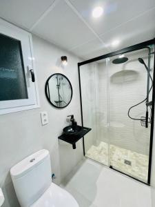 een badkamer met een douche, een toilet en een wastafel bij Apartamento Torreón De La Huerta in Córdoba