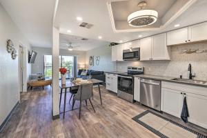 a kitchen with white cabinets and a table and a dining room at Resort-Style Lake Havasu City Condo with Pool! in Lake Havasu City