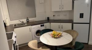 a kitchen with a table with a bowl of fruit on it at Spacious One Bedroom Apartment in Sulhampstead Abbots