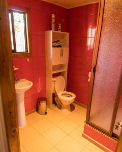 czerwona łazienka z toaletą i umywalką w obiekcie Cabañas Jazmín w mieście Palmilla