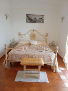 een slaapkamer met een groot bed en een kruk bij B&B Baia Turchese in Porto Ottiolu