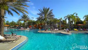 a pool at a resort with palm trees and chairs at Rooms SWEET Rooms in Davenport