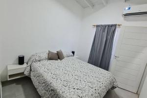 1 dormitorio con 1 cama con edredón gris en Alojamiento San Rafael Pet Friendly en San Rafael