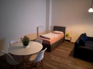 エムデンにあるAppartement Alte Kaserneのベッド、テーブル、椅子が備わる小さな客室です。