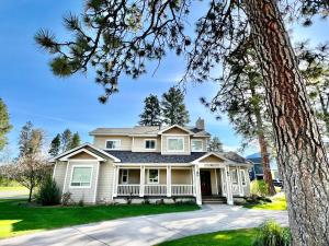 een wit huis met een boom ervoor bij Talbot Pines in Columbia Falls