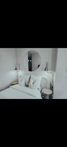 a white bedroom with a bed and a chair at Suite Onega in Lyon