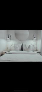 a white bed with two lights on top of it at Suite Onega in Lyon