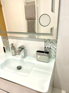 a white bathroom with a sink and a mirror at The Quay in Newhaven
