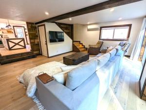 - un salon avec un grand canapé et une télévision dans l'établissement Tall Timbers Cabin, à West Glacier