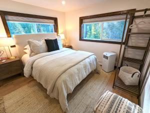 - une chambre avec un grand lit et 2 fenêtres dans l'établissement Tall Timbers Cabin, à West Glacier