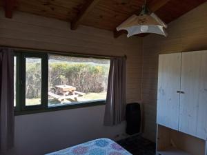 1 dormitorio con ventana y mesa de picnic al aire libre en La casa de la abuela Cabaña en El Bolsón