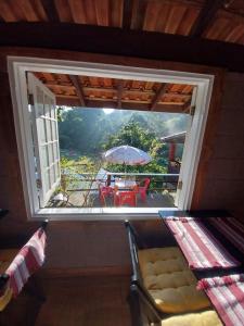 a window in a room with a table and an umbrella at Pousada Beija flor in Extrema