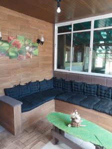 a room with a blue couch and a window at Pousada Beija flor in Extrema