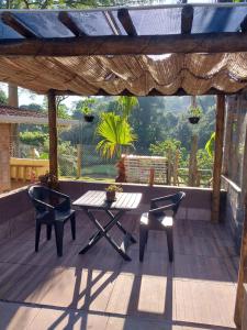 a patio with a table and chairs on a deck at Pousada Beija flor in Extrema