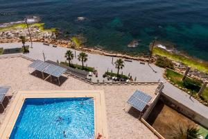 uma vista sobre uma piscina e uma praia em RUMOHOLIDAYS Proa Playa Del Cura em Torrevieja