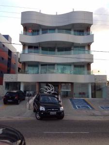 un coche aparcado frente a un edificio en Flat com varanda beira-mar, en João Pessoa