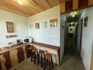 Poas Volcano Rooms في Fraijanes: مطبخ مع كونتر وكراسي في غرفة
