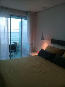 1 dormitorio con 2 camas y vistas al océano en Flat com varanda beira-mar, en João Pessoa