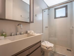 a bathroom with a sink and a toilet and a shower at Allure 102 - Apto em Gramado Av das Hortênsias in Gramado