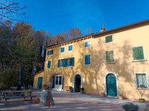 un gran edificio amarillo con un banco delante en Agriturismo Croce del Gal, en Verona