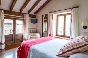1 dormitorio con 1 cama con manta roja en Excepcional Casa El Olivo, en Ojedo
