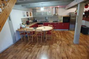 kuchnia ze stołem i krzesłami w pokoju w obiekcie Grand appartement neuf avec parking gratuit. w mieście Malbuisson