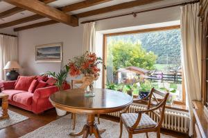 uma sala de estar com uma mesa e um sofá vermelho em Excepcional Casa El Olivo em Ojedo