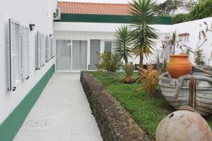 une passerelle devant une maison avec des plantes dans l'établissement Quinta de Santa Bárbara Casas Turisticas, à Lagoa
