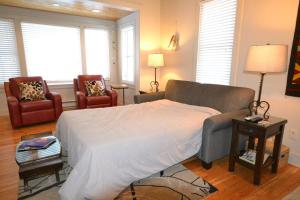 ein Schlafzimmer mit einem großen Bett und zwei Stühlen in der Unterkunft Walker's Cottage in Whitefish